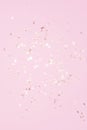 Gold shiny flying confetti on a pink background festive backdrop
