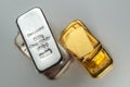 Gold and silver bars of various weights on a grey background Royalty Free Stock Photo