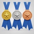 Gold, silver, and bronze medals with blue ribbons, representing first, second, and third place awards Royalty Free Stock Photo