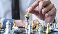 Gold and silver chess with player, Hands of businessman moving chess figure in competition to planning strategy to success play