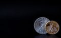 A gold and silver coin in corner of a black backdrop Royalty Free Stock Photo