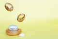 Gold and silver Easter eggs levitation to the nest on a yellow background. Easter concept. Copy space Royalty Free Stock Photo