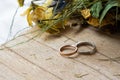 Gold and silver engagement rings on wooden table.