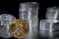 Gold and silver one ounce coins infront of stacks of silver coins Royalty Free Stock Photo