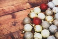 Gold,silver and red christmas baubles on a wooden background