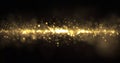 Gold sparkling glitter light wave, sparkling particles shine flow with bokeh effect. Glowing gold sparks and glittering sparkling Royalty Free Stock Photo