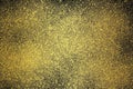 Gold spray textured graphic on dark background