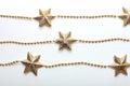 Gold star and bead garland on white backgroun. Flat lay. Top view