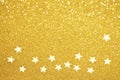 Gold star confetti glitter background. Shiny holiday golden decoration. Defocused bokeh lights