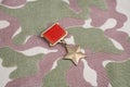 The Gold Star medal is a special insignia that identifies recipients of the title Hero in the Soviet Union on Soviet camouflag Royalty Free Stock Photo