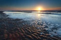 Gold sunset over North sea sand beach at low tide