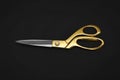 Gold tailor scissors on black background