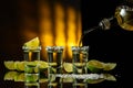 Gold tequila with sea salt and lime slices on a black reflective background Royalty Free Stock Photo