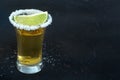 Gold tequila shot, with a salt rim and a lime slice, on a black background Royalty Free Stock Photo