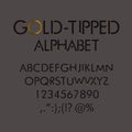 Gold-tipped alphabet with numbers and punctuation marks.