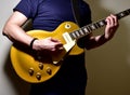 Man playing a gold top electric guitar with P90 pickups. Royalty Free Stock Photo