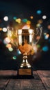 Gold trophy over wooden table and dark background with abstract shiny lights, symbolizing victory Royalty Free Stock Photo