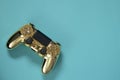 a gold video game controller on a blue background Royalty Free Stock Photo