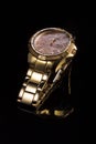 Gold watch on a plastic background Royalty Free Stock Photo