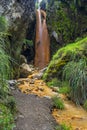 Vertical shot of the tropical golden waterfall located in the foothills of the volcano Illinizas Sur