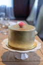 Gold wedding cake with edible rose flower topper.