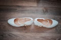 Gold wedding ring between pair of a white shoes Royalty Free Stock Photo