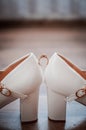 Gold wedding ring between pair of a white shoes Royalty Free Stock Photo