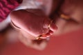 Gold wedding ring on a Tender cute foot of a just born baby