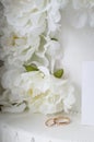 Gold wedding rings on a background of white decorative flowers. Vertical photography Royalty Free Stock Photo