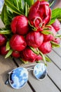 gold wedding rings close-up on a background of a bouquet dark red burgundy peony with green leaves,on the table sunglasses Royalty Free Stock Photo