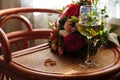 Gold wedding rings, a glass of champagne, bouquet on the table Royalty Free Stock Photo