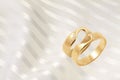 Gold wedding rings on golden festive background