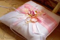 Gold wedding rings lie on a decorative silk pillow with pink satin ribbons Royalty Free Stock Photo