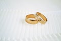 Gold wedding rings on light ribbon background