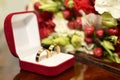 Gold wedding rings in a red box on the background of a wedding bouquet Royalty Free Stock Photo