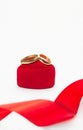 Gold wedding rings on red velvet gift box heart with ribbon on white background Royalty Free Stock Photo