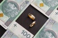 Gold wedding rings surrounded by a stack of Polish banknotes Royalty Free Stock Photo