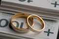 Gold wedding rings surrounded by a stack of Polish banknotes Royalty Free Stock Photo