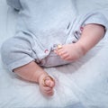 Gold wedding rings on the toes of the new born baby`s legs Royalty Free Stock Photo