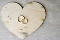 Gold wedding rings on a wooden heart. Bright, glittering, glamorous, fashionable, expensive hearts made of wood with adornments fo Royalty Free Stock Photo