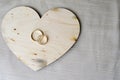 Gold wedding rings on a wooden heart. Bright, glittering, glamorous, fashionable, expensive hearts made of wood with adornments fo