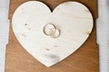 Gold wedding rings on a wooden heart. Bright, glittering, glamorous, fashionable, expensive hearts made of wood with ornaments for Royalty Free Stock Photo