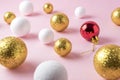 Gold and white glitter ball decoration with red Christmas bauble on pink background. Royalty Free Stock Photo