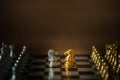 Gold and white knights facing together in center of chess board between black and white team Royalty Free Stock Photo