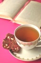 Gold and white porcelain tea cup and saucer with artisan chocolate on bright fuchsia pink background with copy space Royalty Free Stock Photo