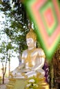 Gold and white sitting Buddha statue at a temple in Thailand Royalty Free Stock Photo