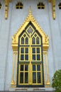 gold window on cement wall in Sotorn temple in Chachoengsao Thailand