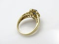 Gold womens ring with diamonds and a blue gem in the form of a flower on a female hand on a white background