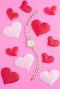 Gold wrist watch with diamonds among hearts Royalty Free Stock Photo