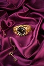 Gold wrist watch lying on the silk cloth